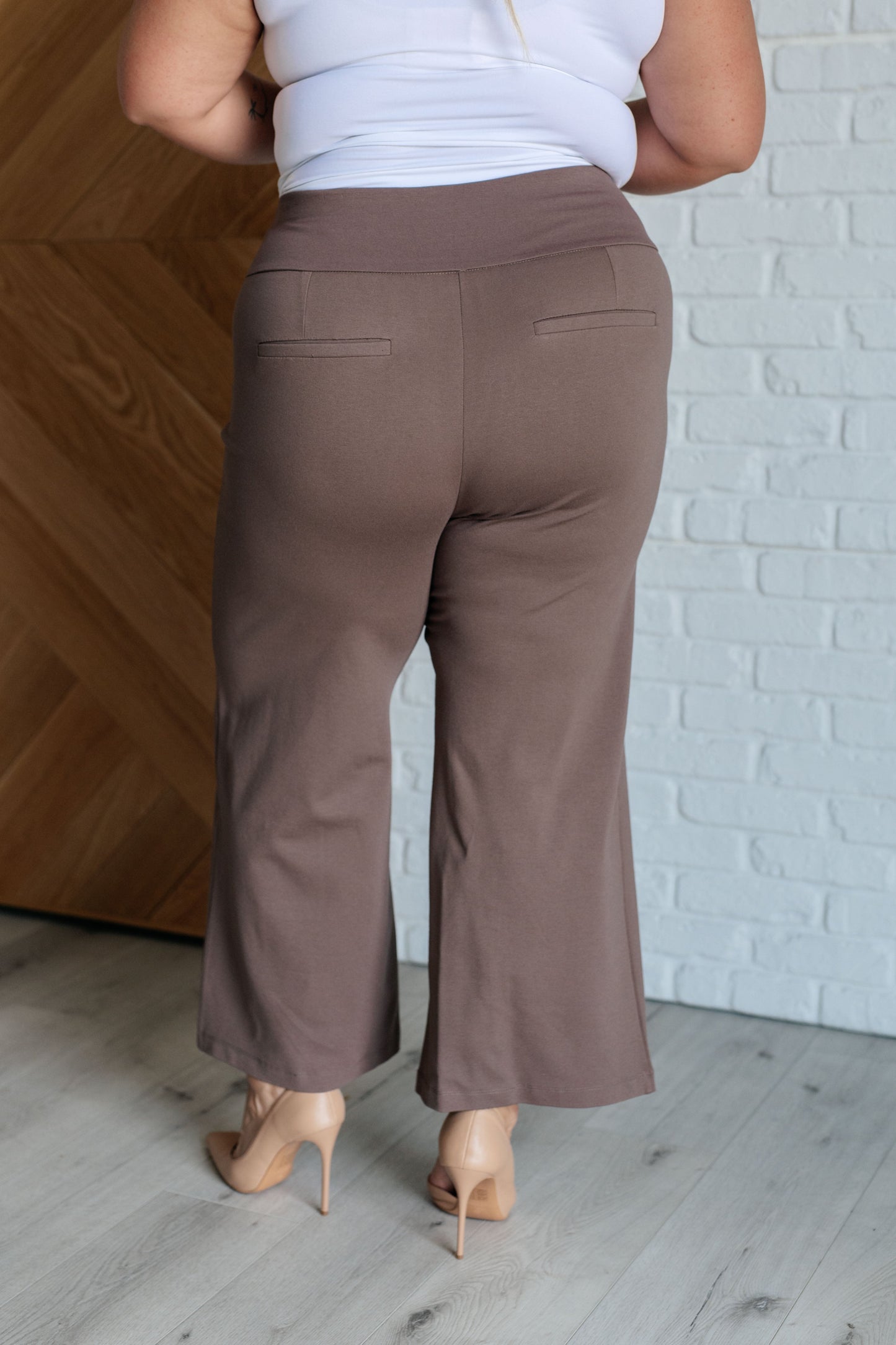 Wide Leg Crop Pants in dark mocha, made from high-stretch ponte knit fabric. Cropped, wide-leg design with faux welt pocket. Perfect for effortless style.