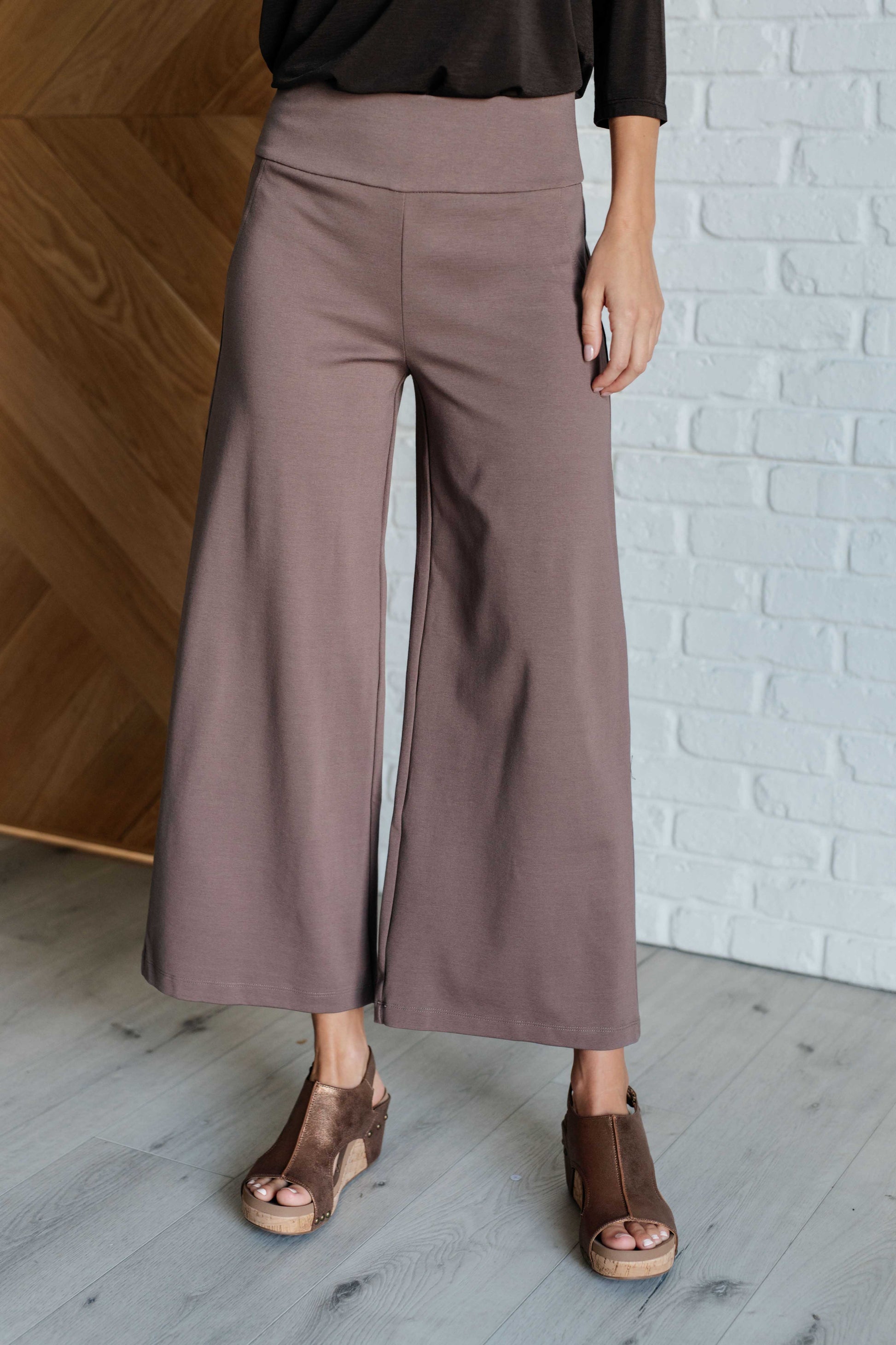 Wide Leg Crop Pants in dark mocha, made from high-stretch ponte knit fabric. Cropped, wide-leg design with faux welt pocket. Perfect for effortless style.