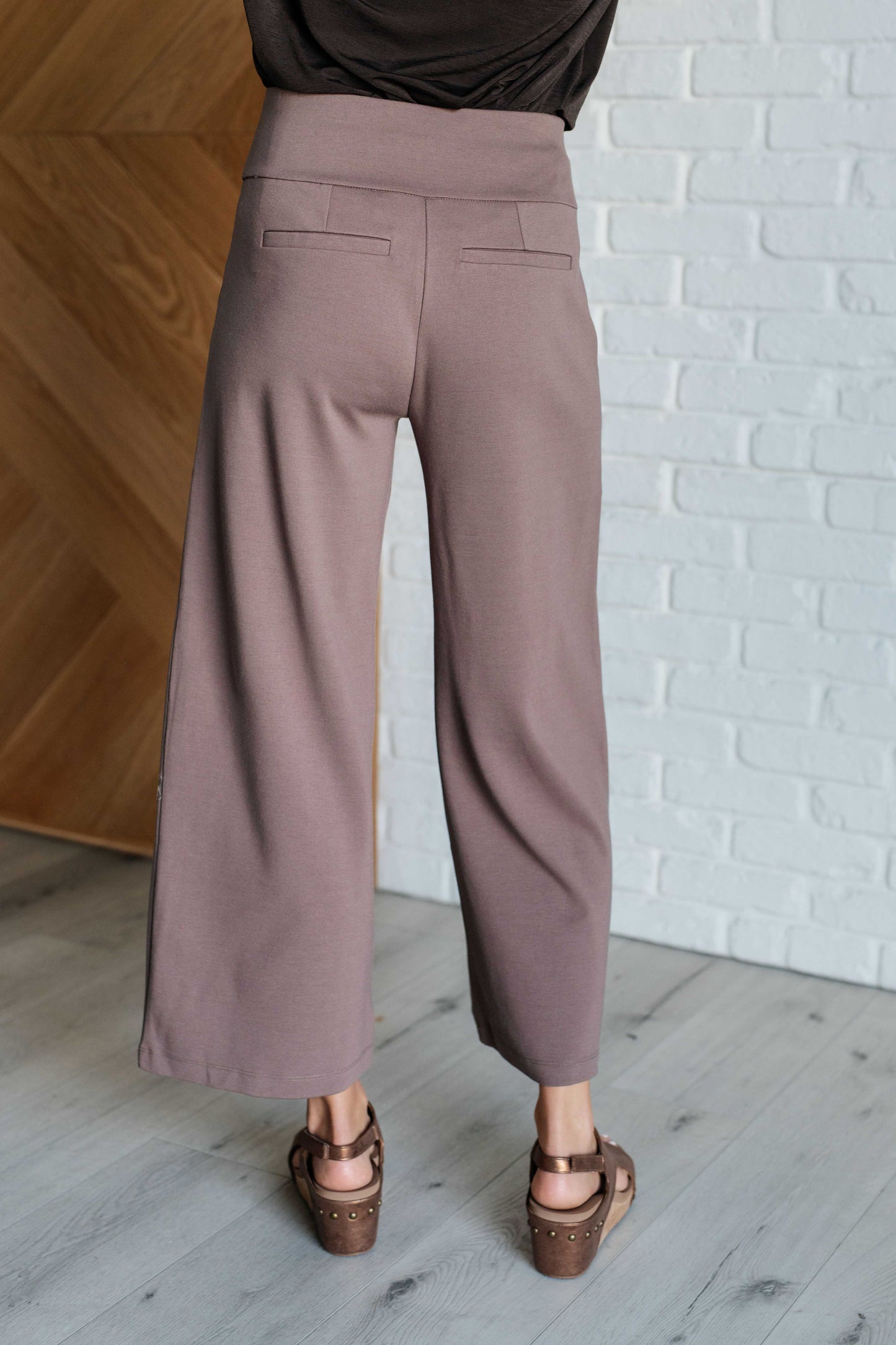 Wide Leg Crop Pants in dark mocha, made from high-stretch ponte knit fabric. Cropped, wide-leg design with faux welt pocket. Perfect for effortless style.