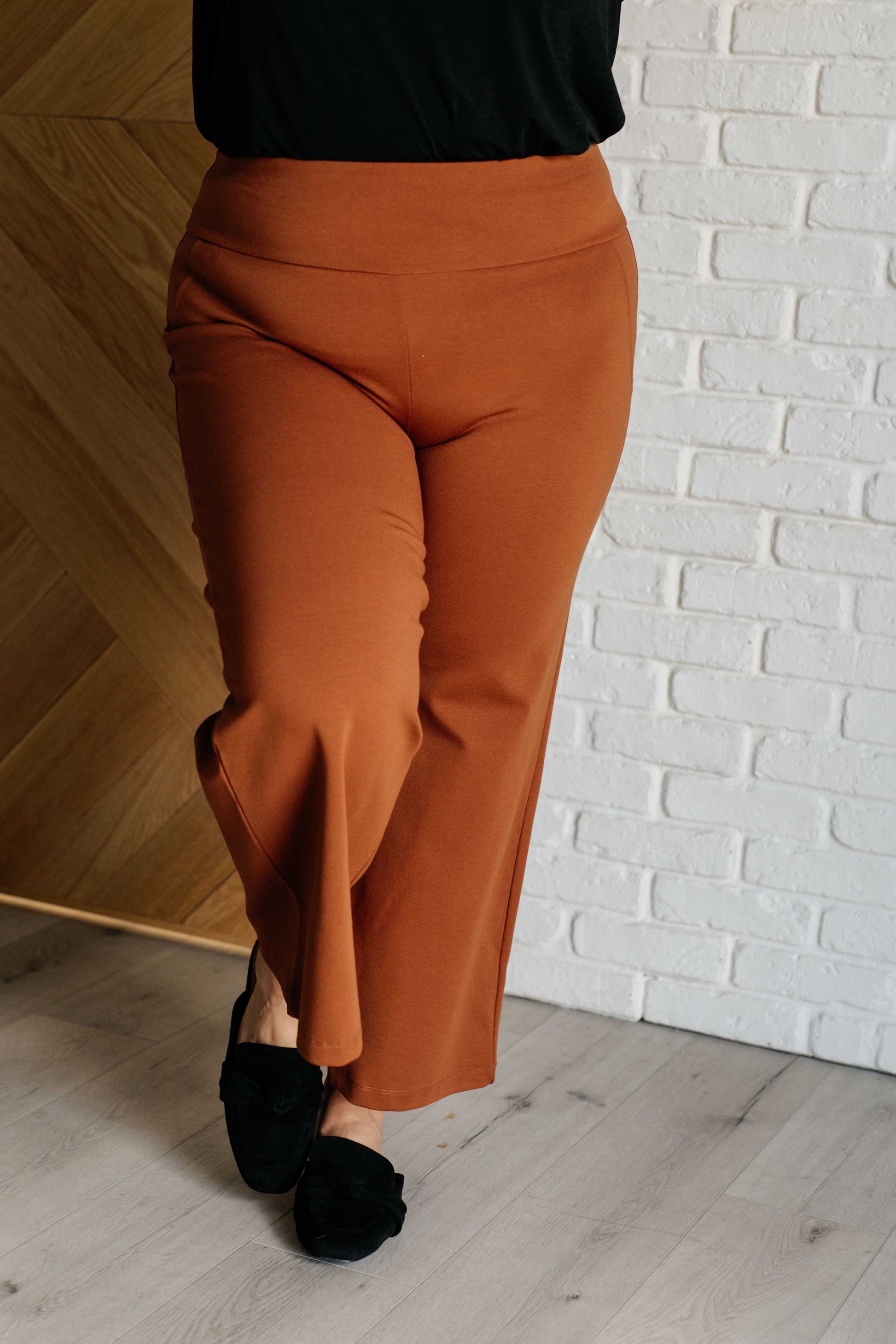 Wide Leg Crop Pants in rust, made from high-stretch ponte knit fabric. Cropped, wide-leg design with faux welt pocket. Perfect for effortless style.