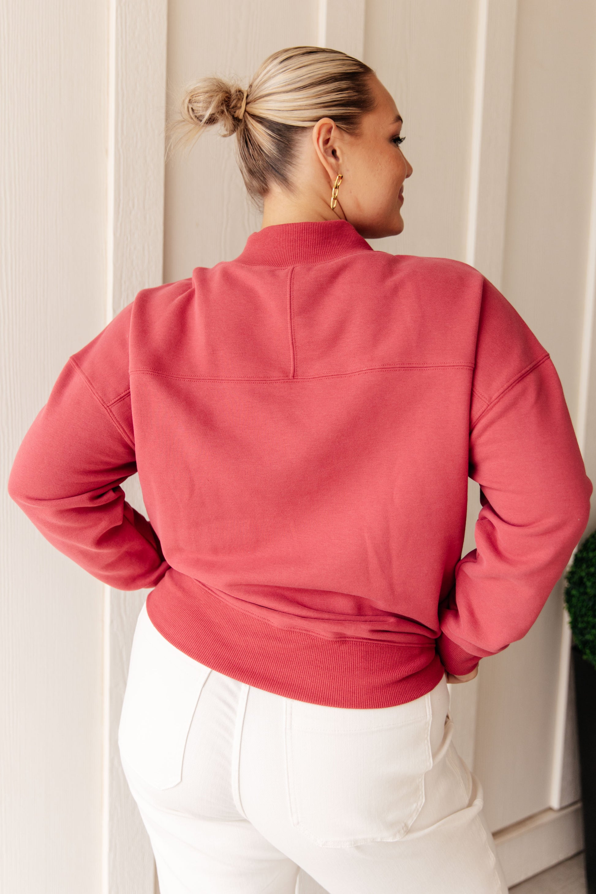 Soft cranberry-colored sweatshirt fleece pullover with a ribbed mock neckline, long sleeves, dropped shoulders, side pockets, and a relaxed fit.