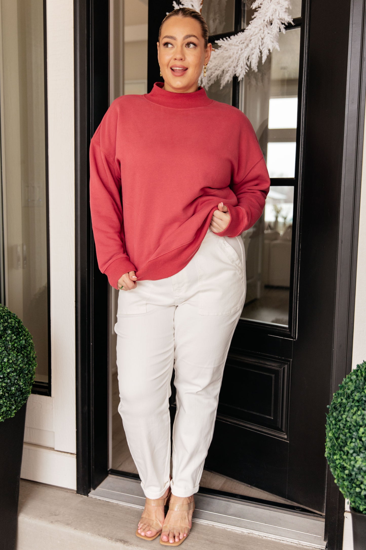 Soft cranberry-colored sweatshirt fleece pullover with a ribbed mock neckline, long sleeves, dropped shoulders, side pockets, and a relaxed fit.