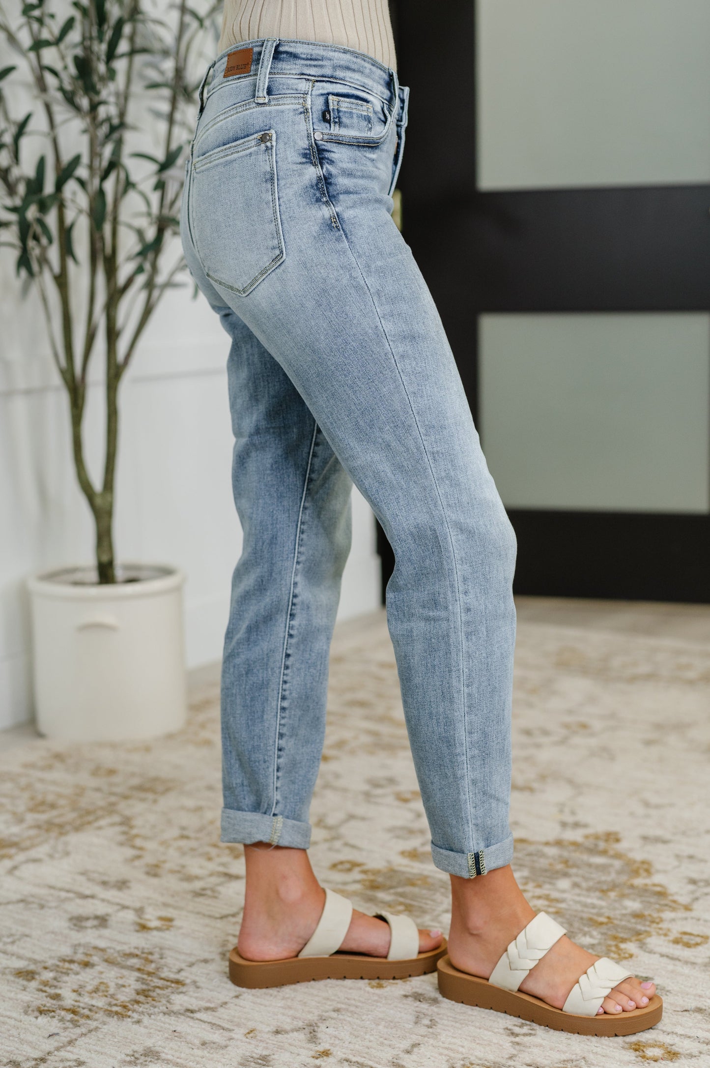 Side view of Mallory mid-rise boyfriend jeans – light wash, size inclusive, with cuffed hems and 4-way stretch.