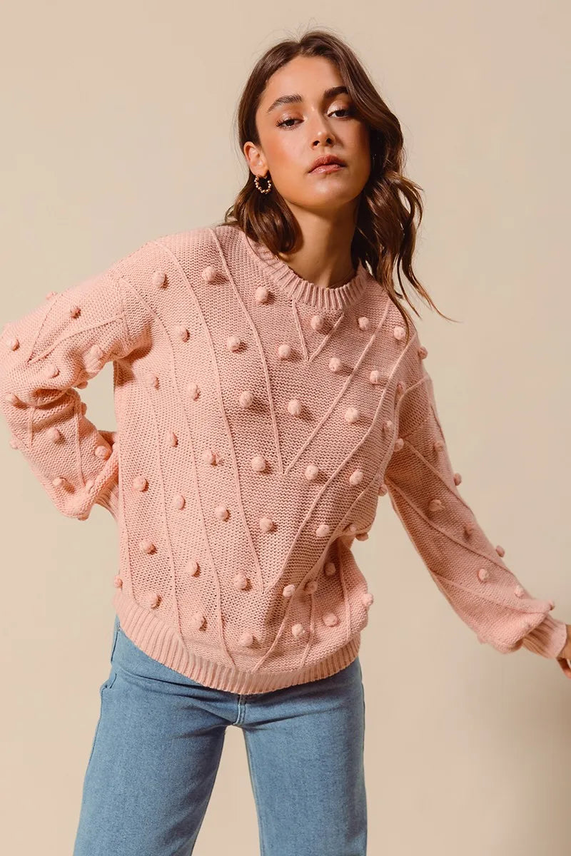 Model in blush pom pom textured knit sweater, showing playful detailing and cozy fabric