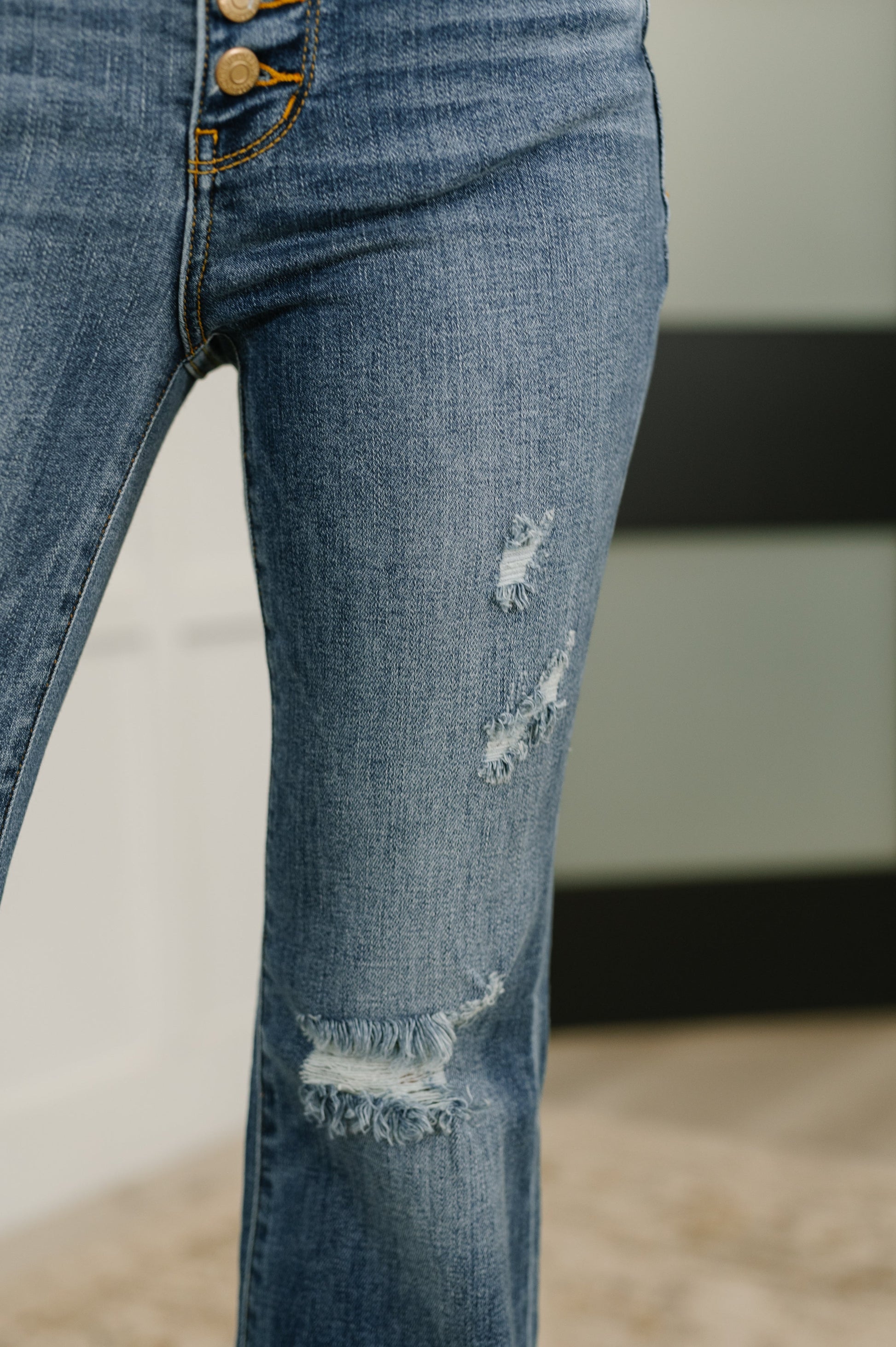 Detail shot of Marion Mid Rise Flare Jeans distressing on leg and soft stretch fabric.
