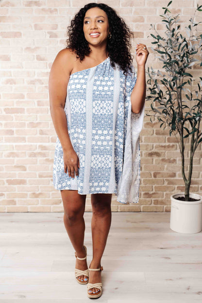 Full body view of plus size model in Marjorie One Shoulder Blue Dress with contrasting print, draped neckline, and shift silhouette.