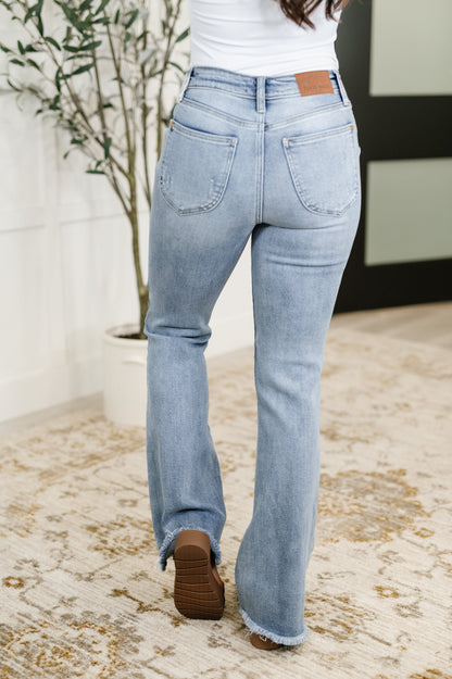 Back view of Marlena High Rise Flare Jeans featuring shield back pockets, raw hemline, and flattering high rise fit.