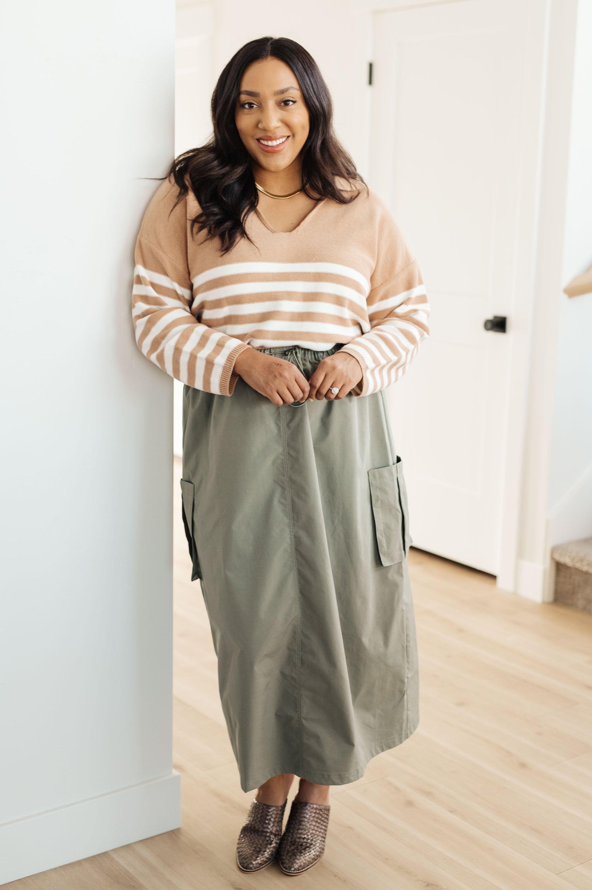 A striped midweight sweater knit in white and beige featuring a collared V-neckline, long sleeves, and a cropped length with a relaxed fit.