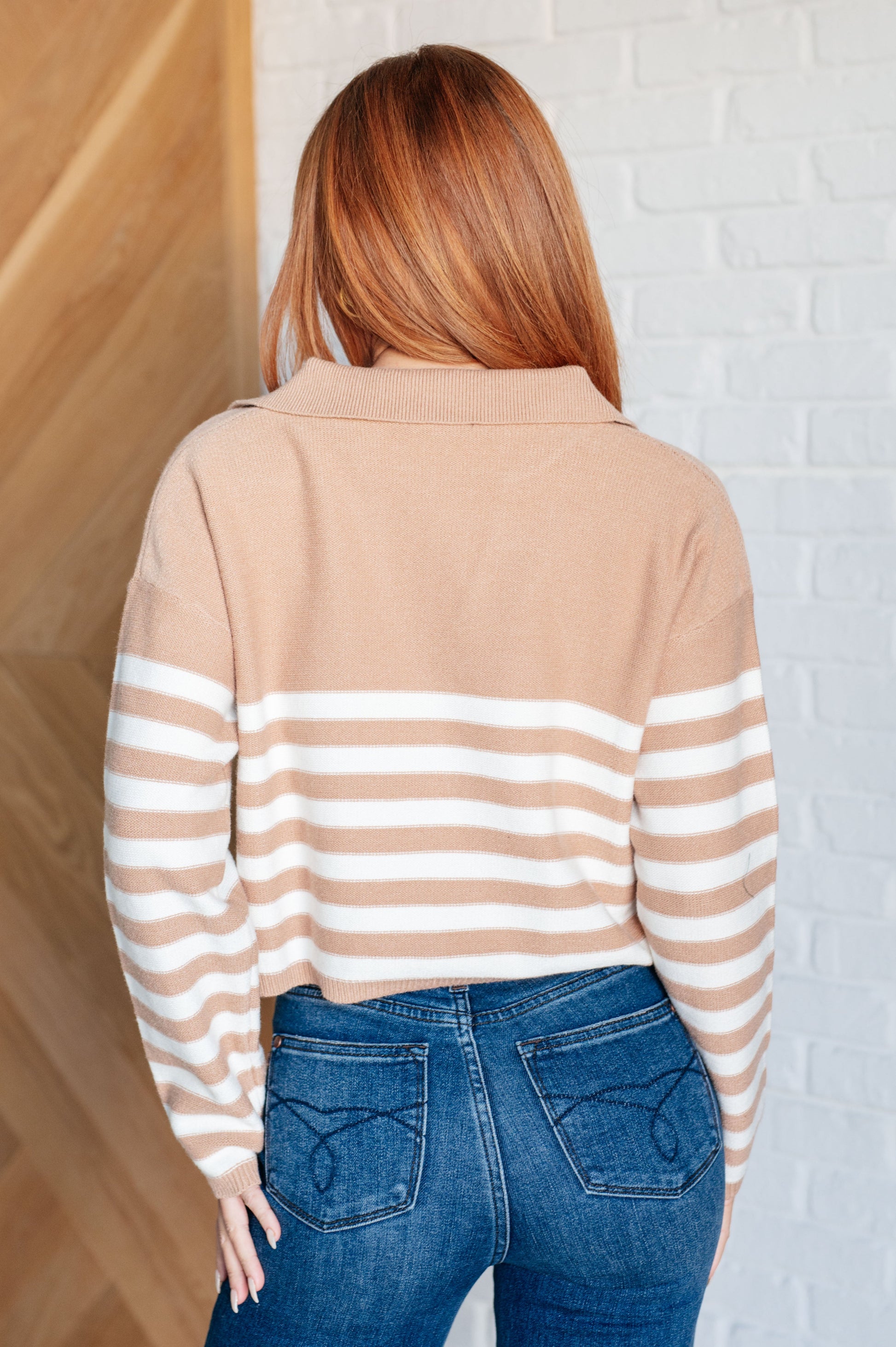 A striped midweight sweater knit in white and beige featuring a collared V-neckline, long sleeves, and a cropped length with a relaxed fit.