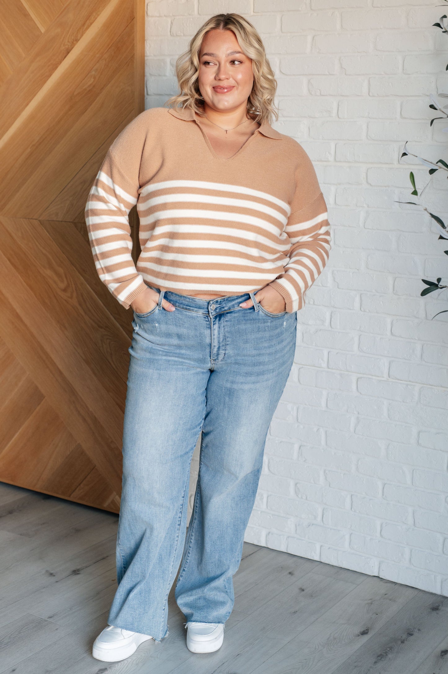 A striped midweight sweater knit in white and beige featuring a collared V-neckline, long sleeves, and a cropped length with a relaxed fit.