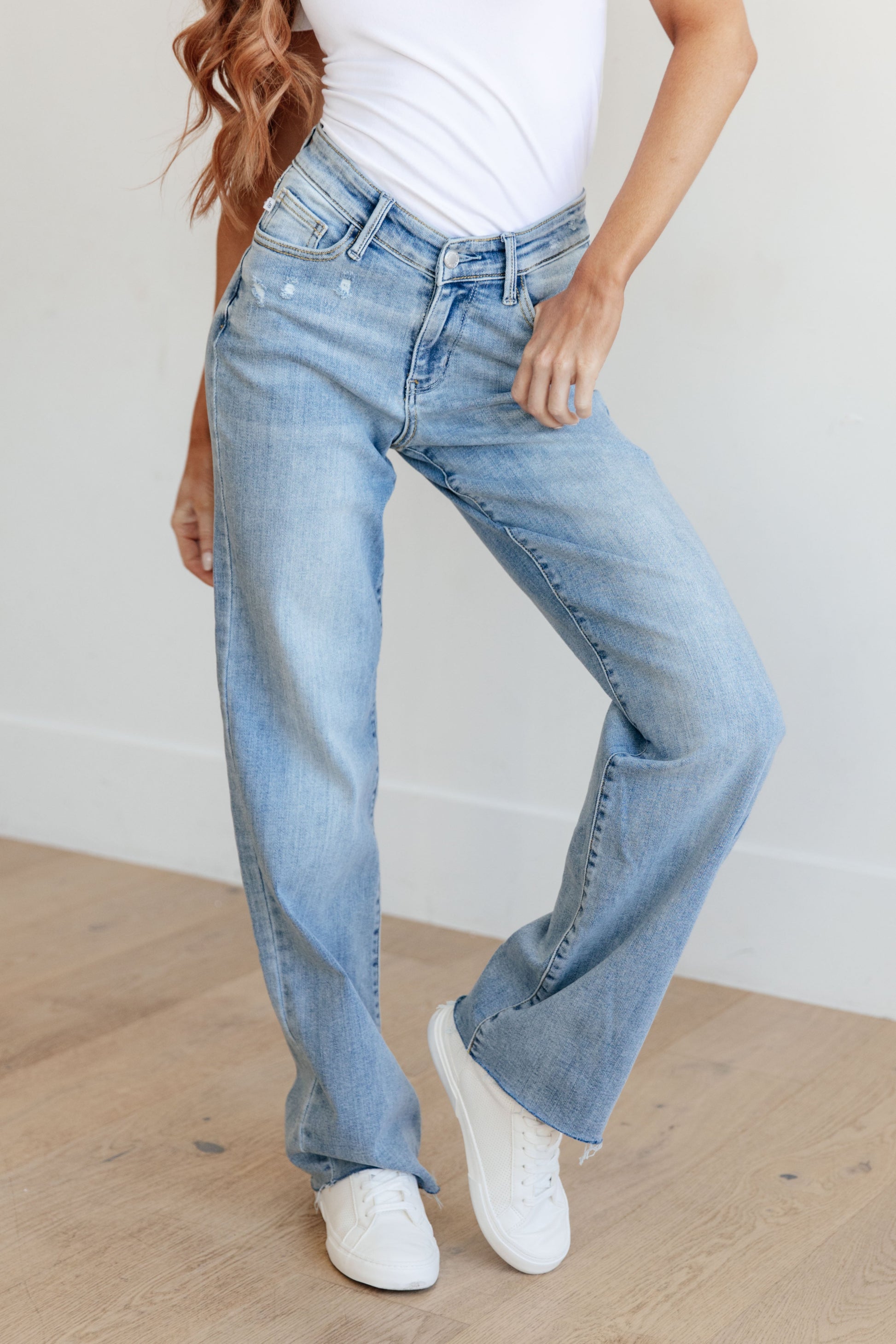 Light wash high-rise straight leg jeans with a V-front waistband, raw hem, and 4-way stretch for a flattering fit and comfort.