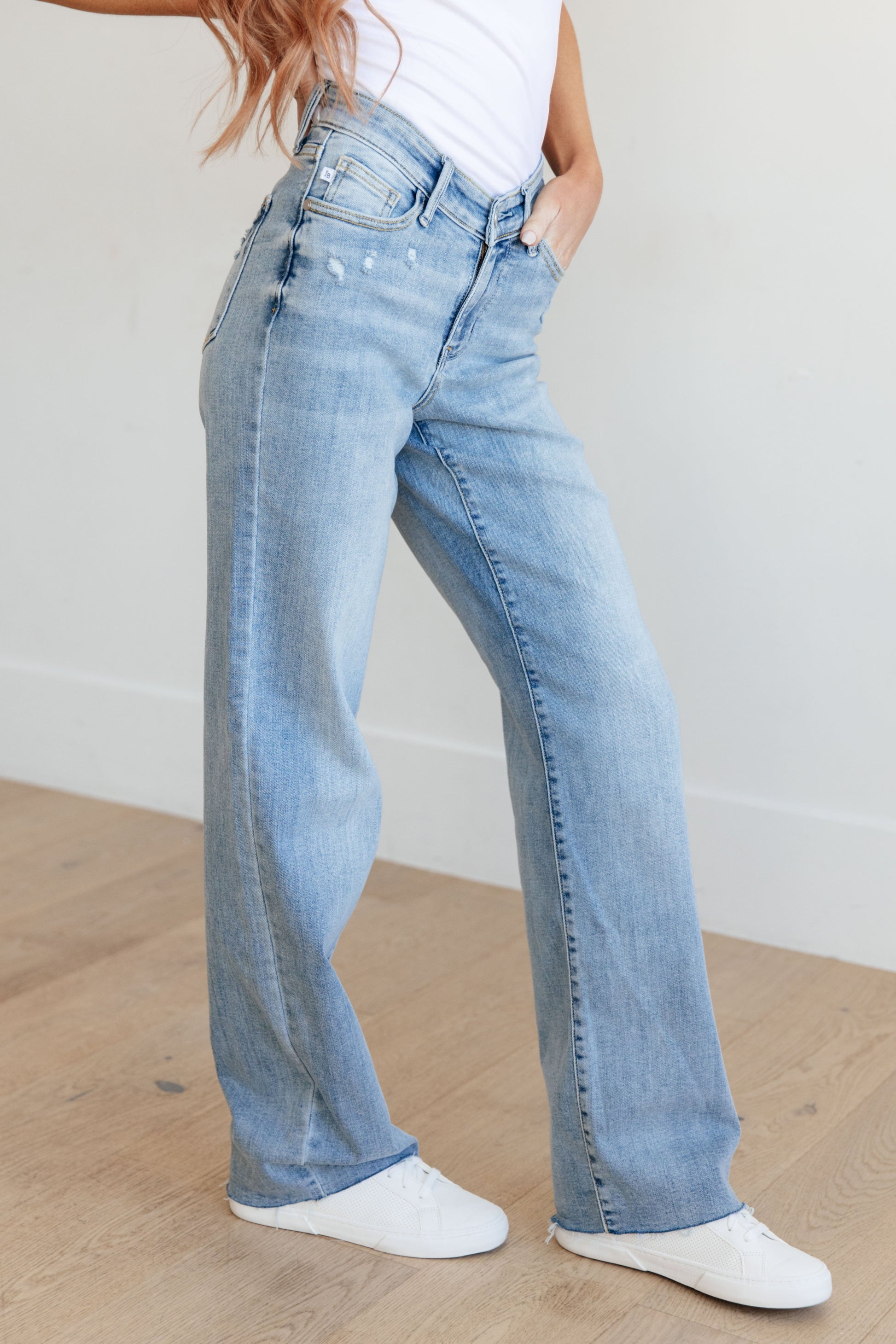 Light wash high-rise straight leg jeans with a V-front waistband, raw hem, and 4-way stretch for a flattering fit and comfort.