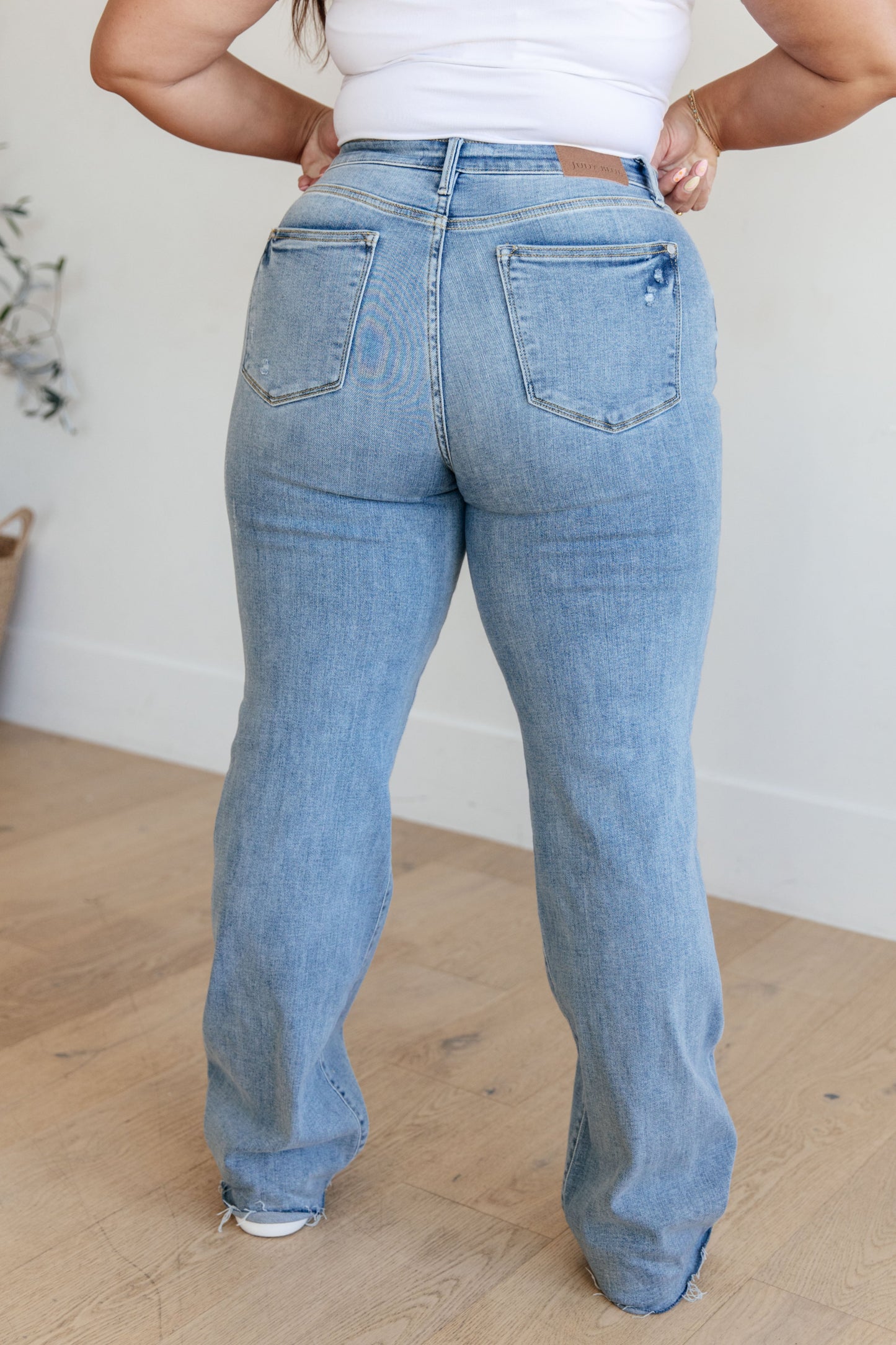 Light wash high-rise straight leg jeans with a V-front waistband, raw hem, and 4-way stretch for a flattering fit and comfort.