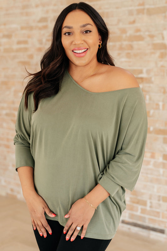 Plus size model front view wearing Micah Sage Long Sleeve Top with boat neckline and dolman sleeves