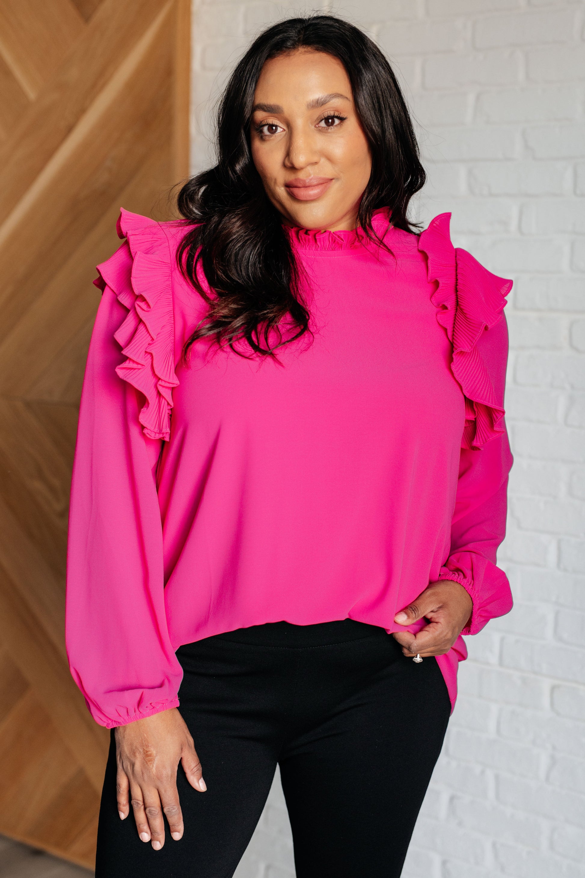 Soft Poly Crepe top in hot pink with mock neckline, ruffle details, long balloon sleeves with elastic cuffs, and keyhole button closure. Lined bodice.