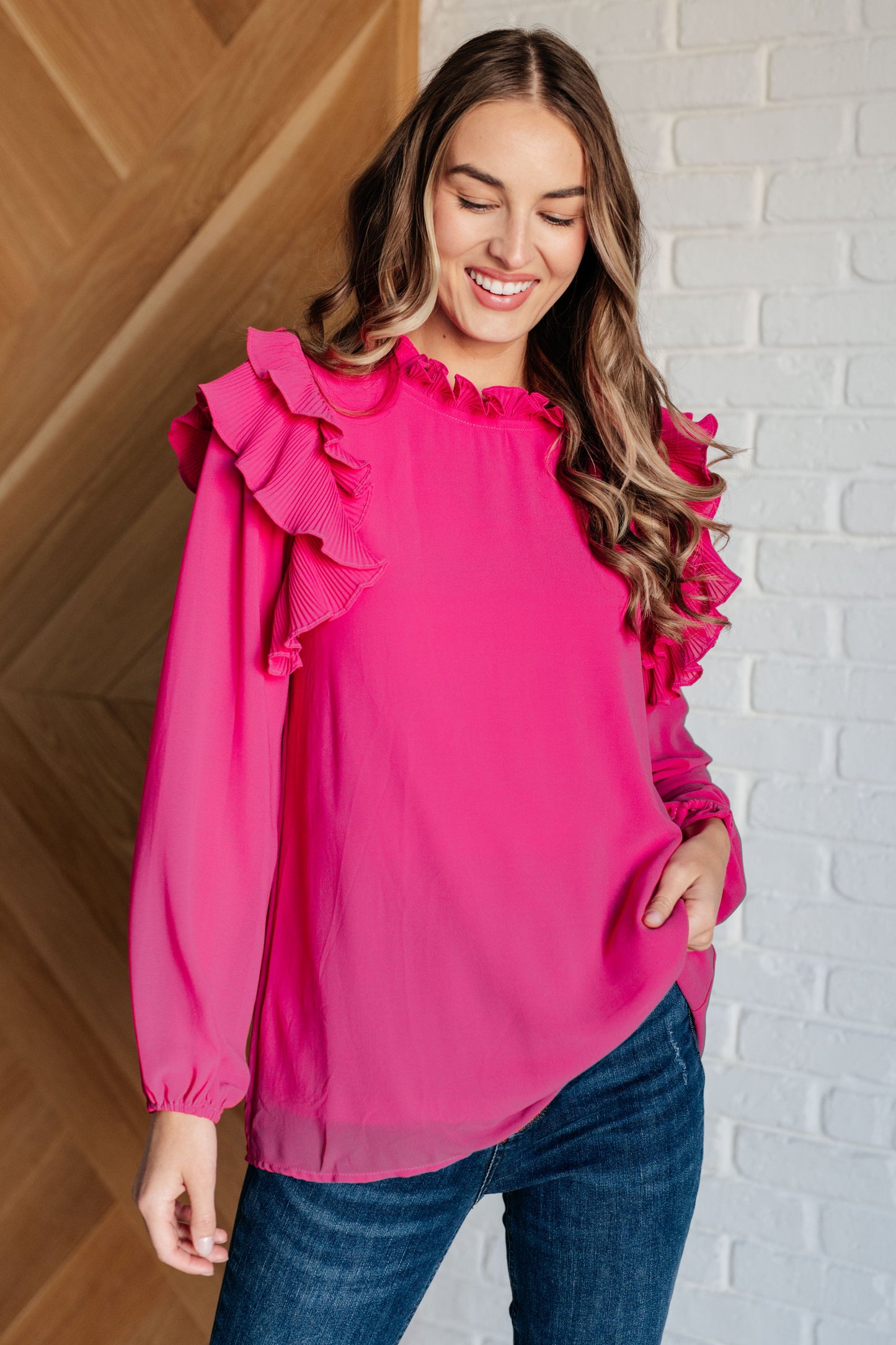 Soft Poly Crepe top in hot pink with mock neckline, ruffle details, long balloon sleeves with elastic cuffs, and keyhole button closure. Lined bodice.