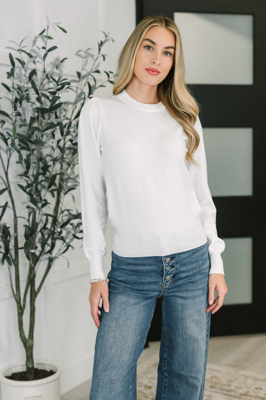 Model wearing Nessy Long Sleeve Top in White with gathered shoulders and ribbed neckline.