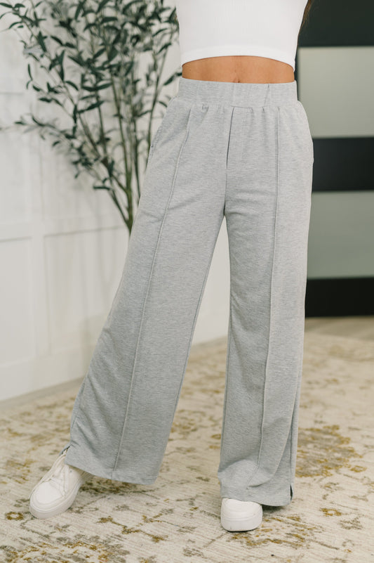 Front view of Jara wide leg pants featuring center seam detail, elastic waistband, and functional side pockets in stretch knit fabric.