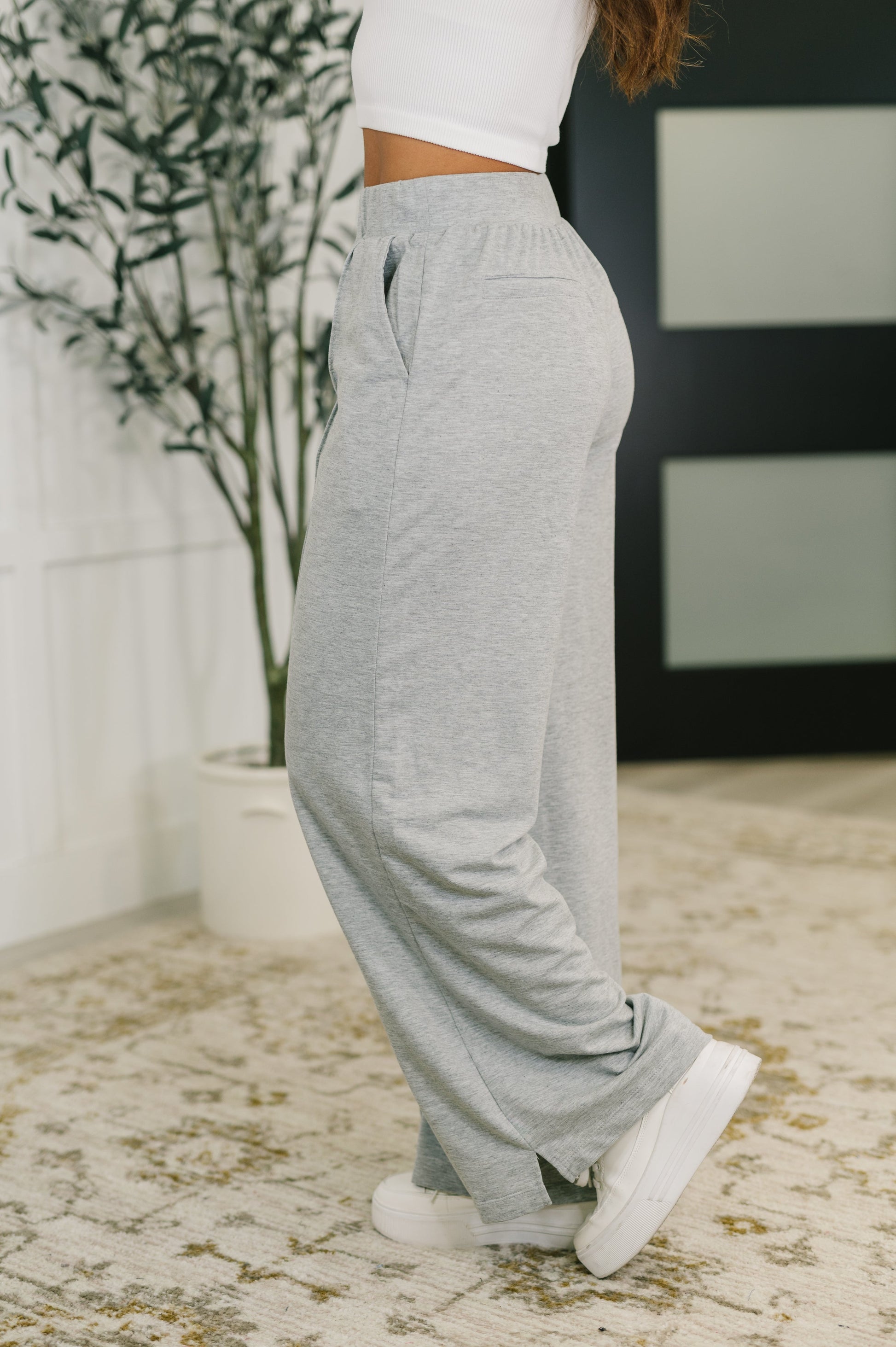Side profile of Jara Wide Leg Pants highlighting wide leg silhouette, cased elastic waistband, and faux welt pocket detail.