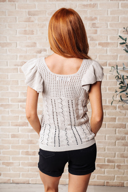 Back of greige pointelle knit top with airy pointelle texture and relaxed sweater knit design.