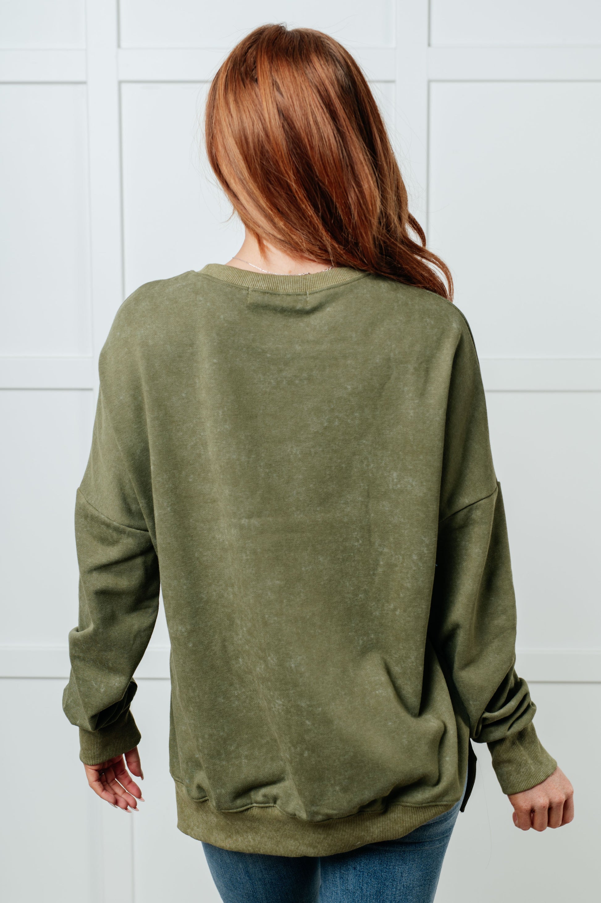 A women's French terry sweatshirt in mineral wash green with a crew neckline, long sleeves, side slits, and ribbed cuffs and hem. 