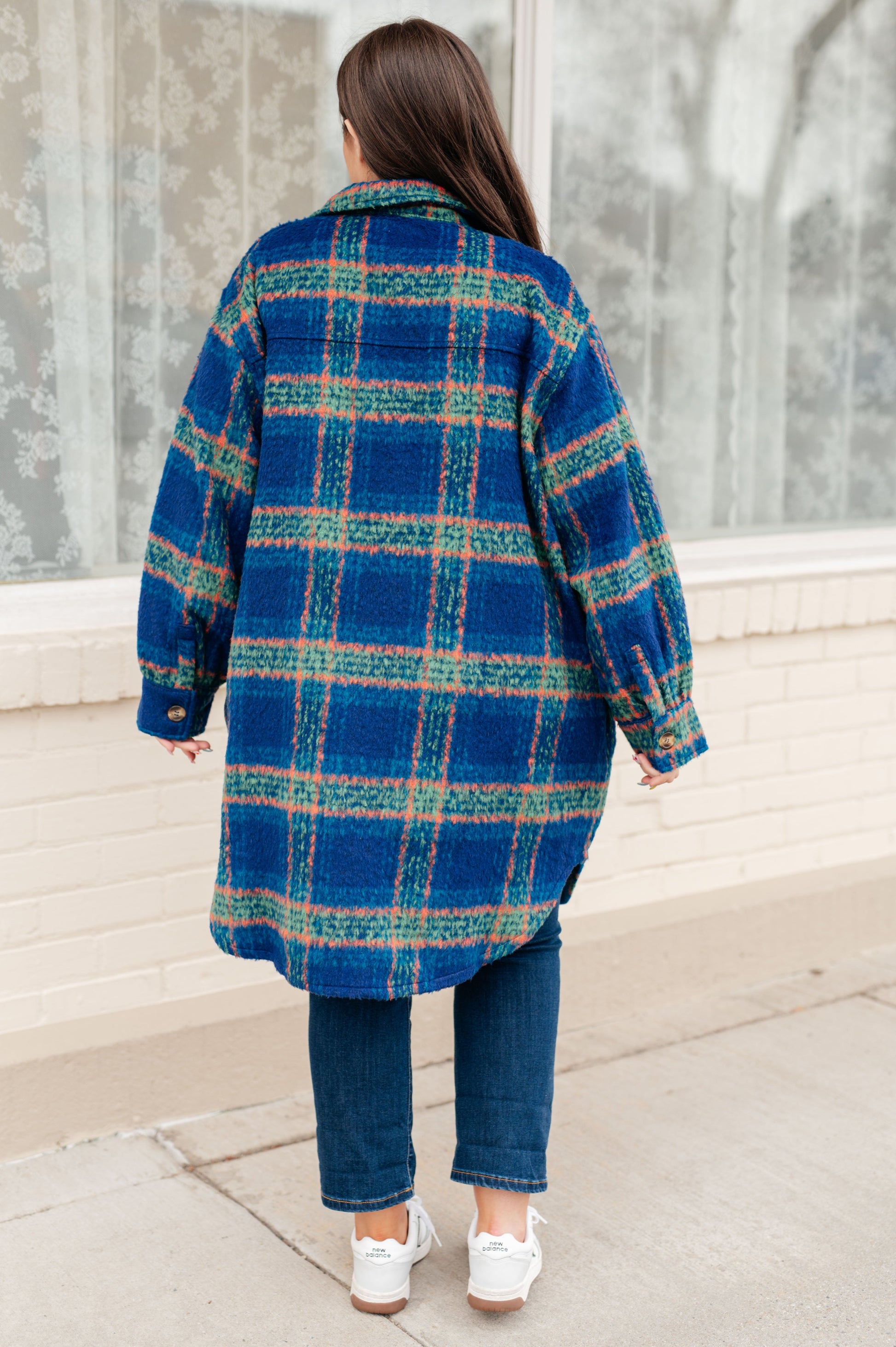 Back view of Nona Plaid Coat in blue plaid with scooped hem detail.