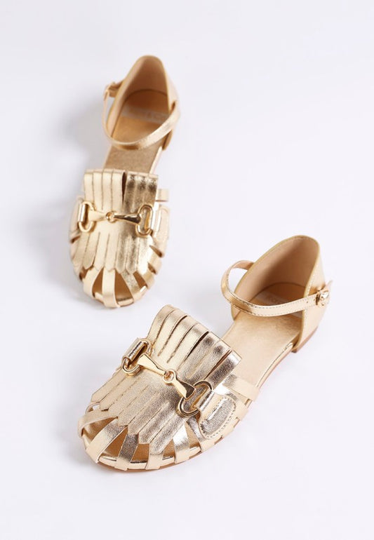 Noori Metallic Fringe Flat Sandals in gold with fringe and horsebit detail.