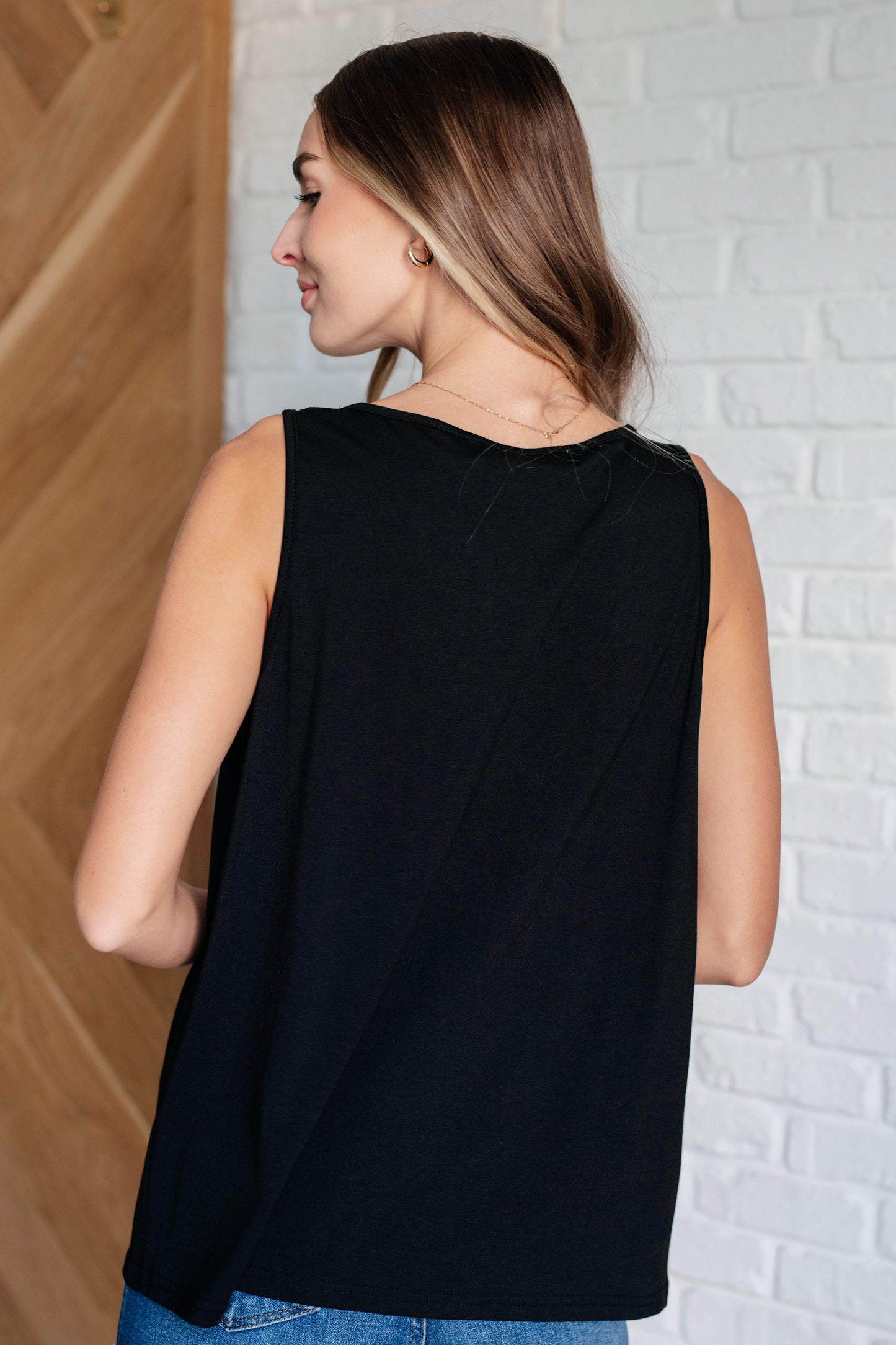 Back view of a lightweight jersey knit tank with a V-neckline, sleeveless cut, and ruched accents, perfect for layering or wearing solo.