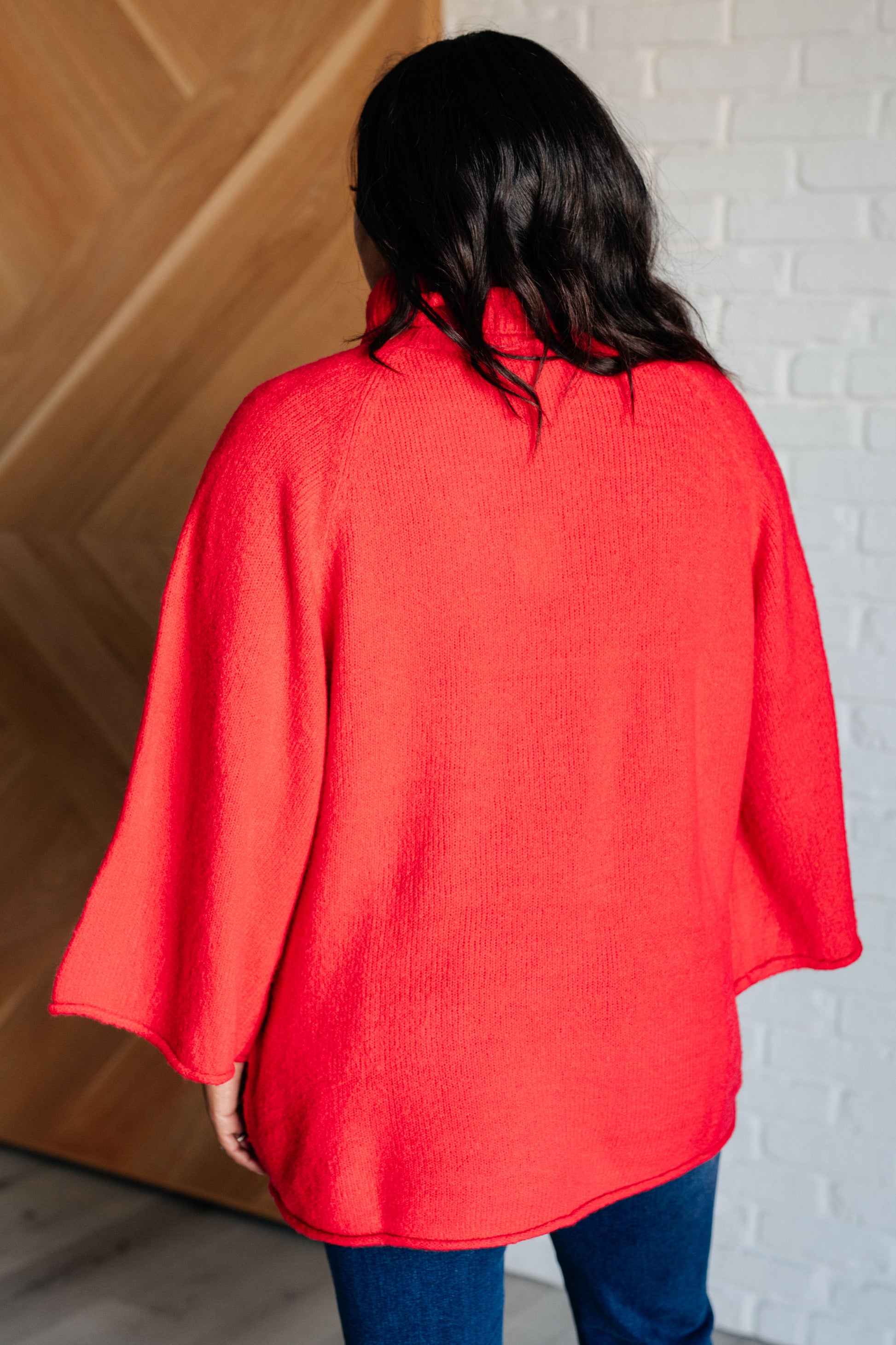 Women's turtleneck sweater in red-orange sweater knit, featuring wide raglan 3/4 length sleeves and a relaxed fit.