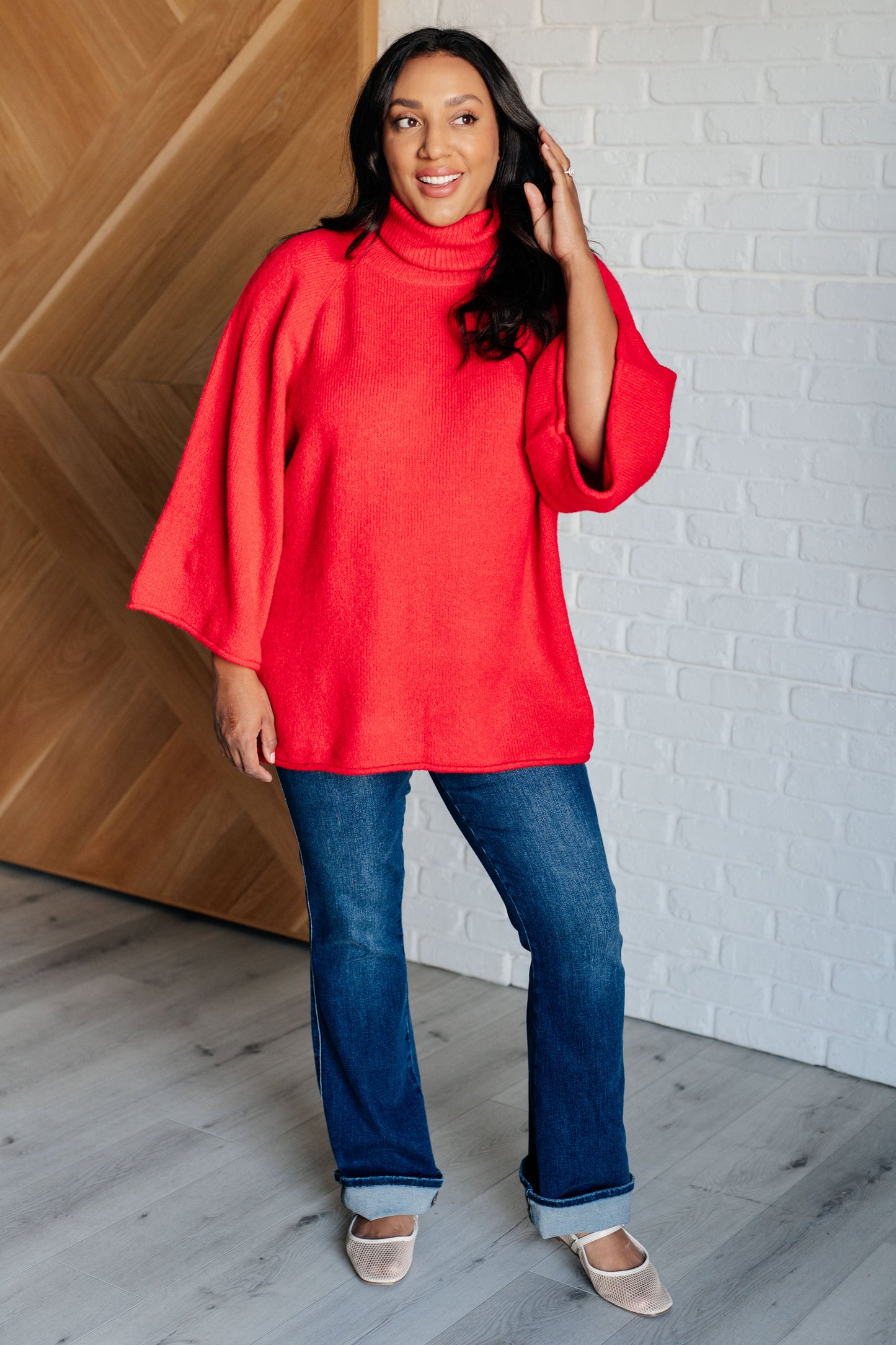 Women's turtleneck sweater in red-orange sweater knit, featuring wide raglan 3/4 length sleeves and a relaxed fit.