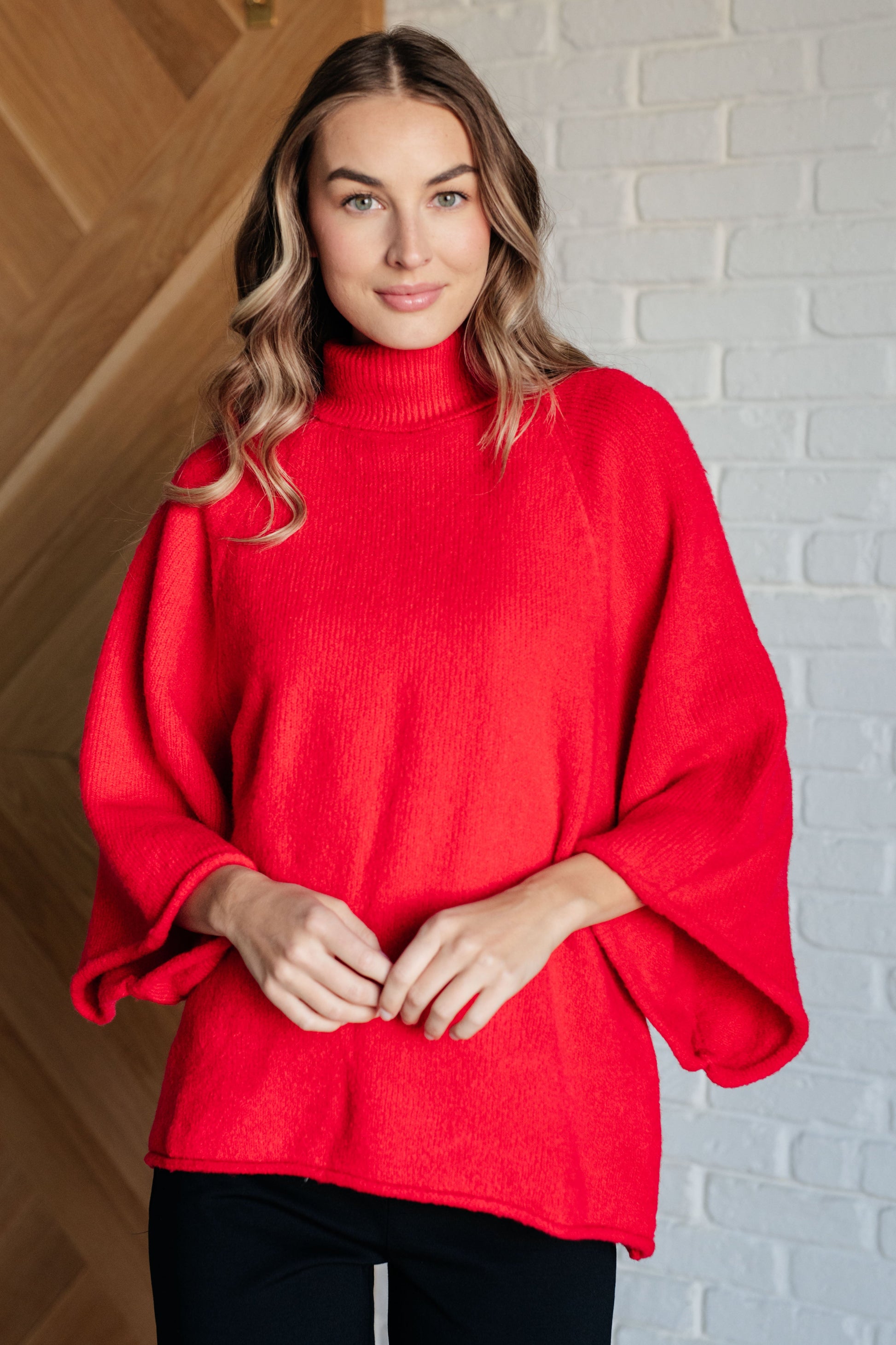 Women's turtleneck sweater in red-orange sweater knit, featuring wide raglan 3/4 length sleeves and a relaxed fit.