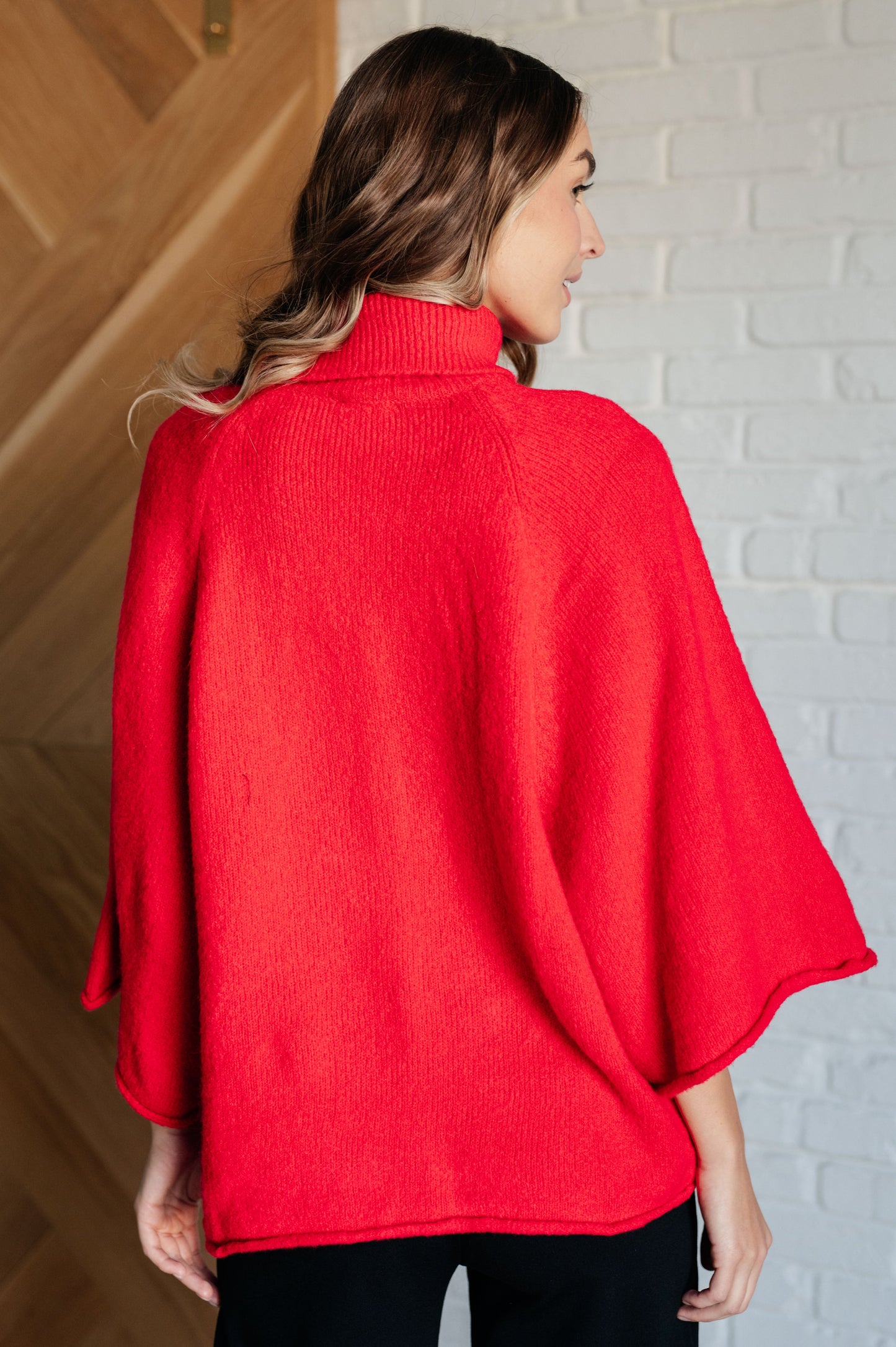 Women's turtleneck sweater in red-orange sweater knit, featuring wide raglan 3/4 length sleeves and a relaxed fit.