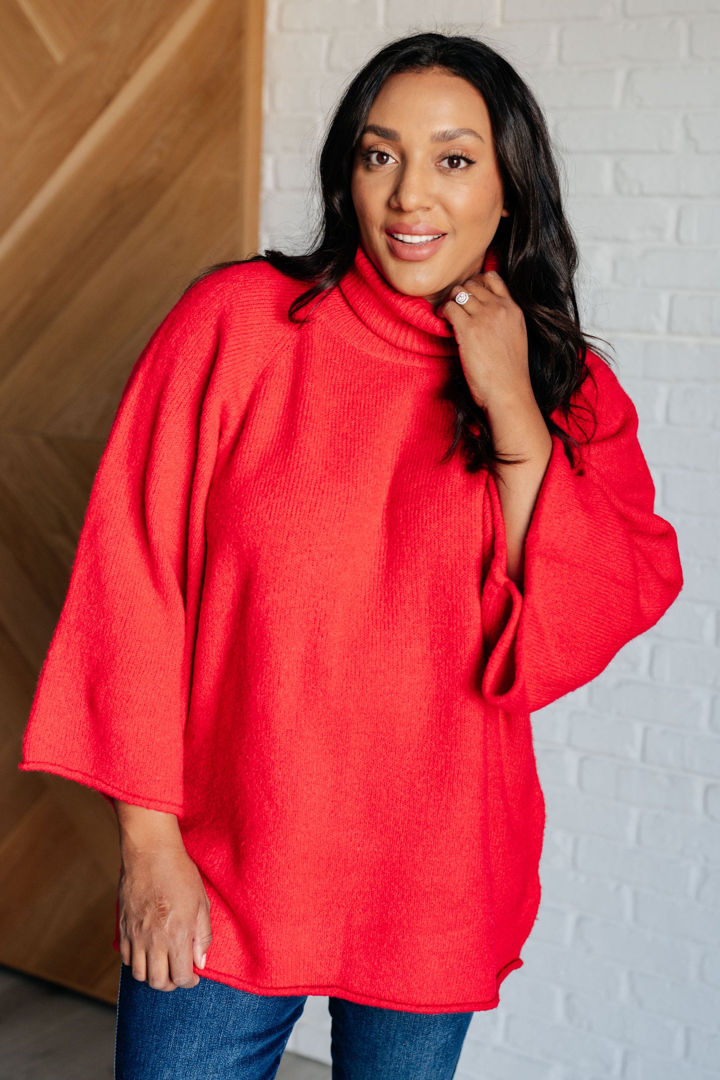 Women's turtleneck sweater in red-orange sweater knit, featuring wide raglan 3/4 length sleeves and a relaxed fit.