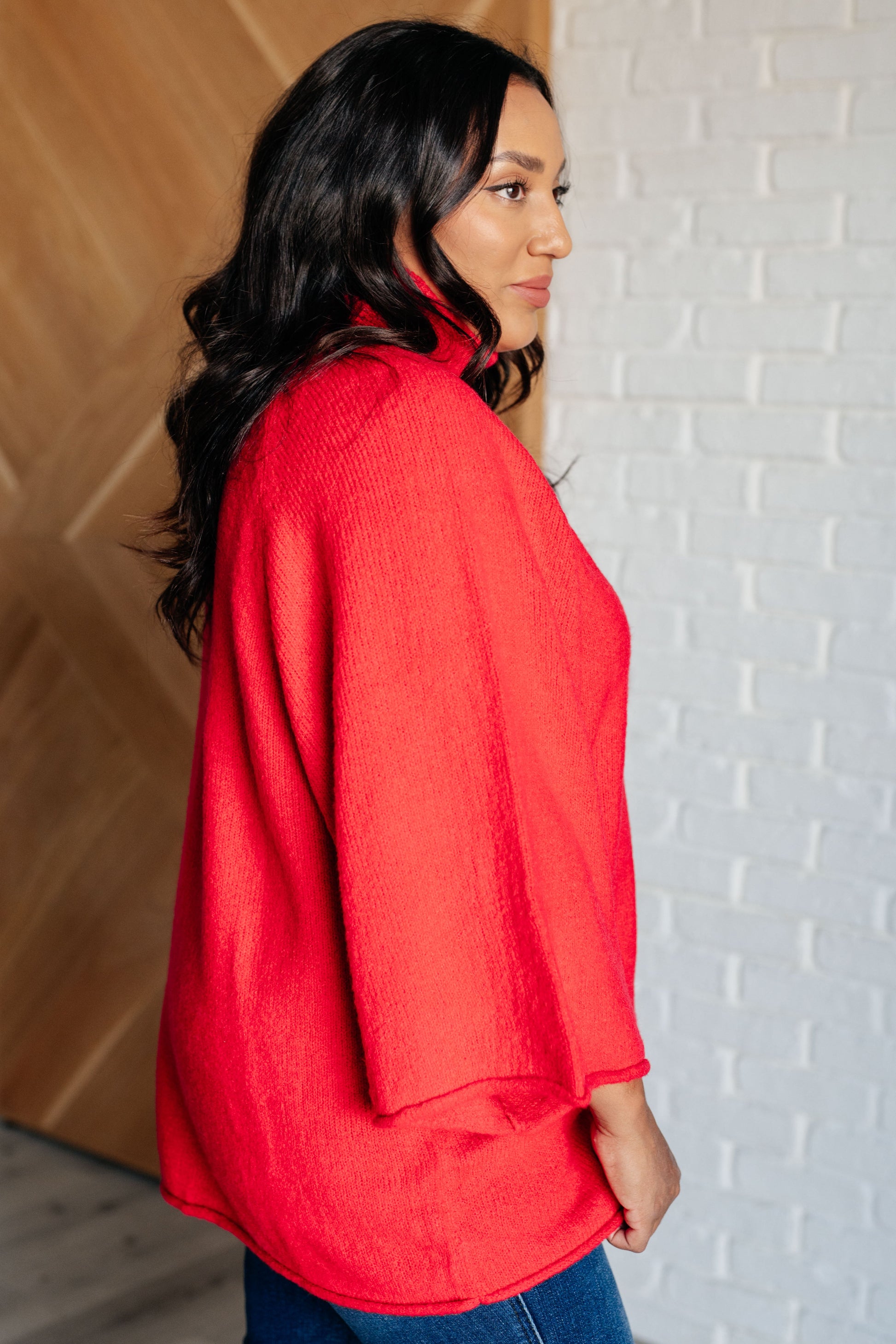 Women's turtleneck sweater in red-orange sweater knit, featuring wide raglan 3/4 length sleeves and a relaxed fit.