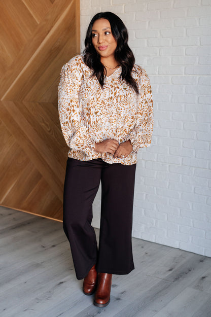 Plus size full body view of Bellamy Keyhole Tie Blouse styled with brown wide-leg pants and boots.