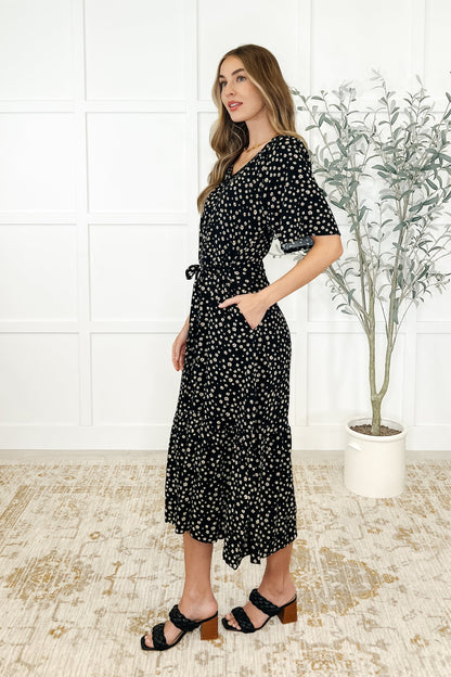 Side view of Olive Daisy Blossom Dress highlighting pockets, tiered design, and daisy floral pattern.