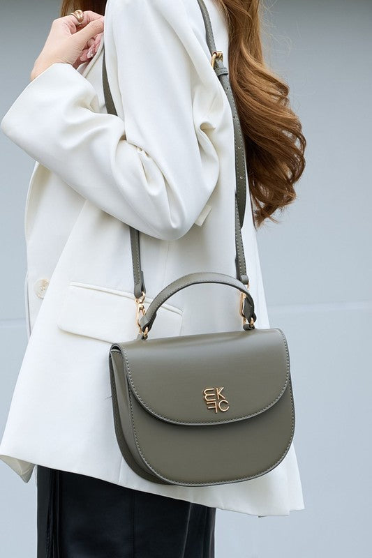 Woman holding olive Heloise Crossbody Bag over shoulder, gold-tone hardware detail visible