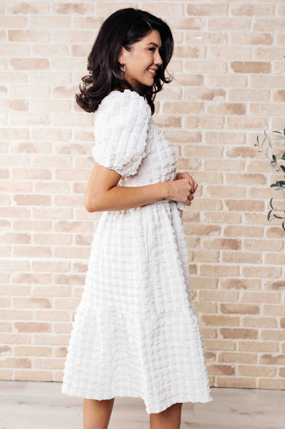 Side view of the Ivy Bubble Midi Dress showing bubble knit texture, tiered skirt, and flattering belted waistline.