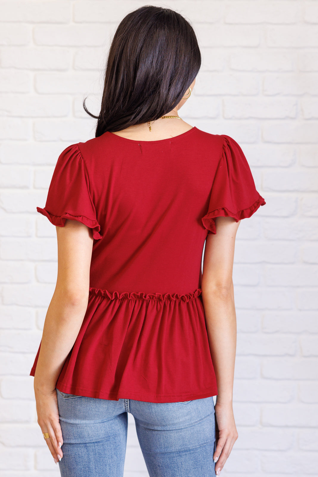 Ophelia V-Neck Ruffle Detail Top in red, featuring a flattering V-neckline, flutter sleeves, peplum silhouette, and charming ruffle accents, perfect for casual or polished occasions.