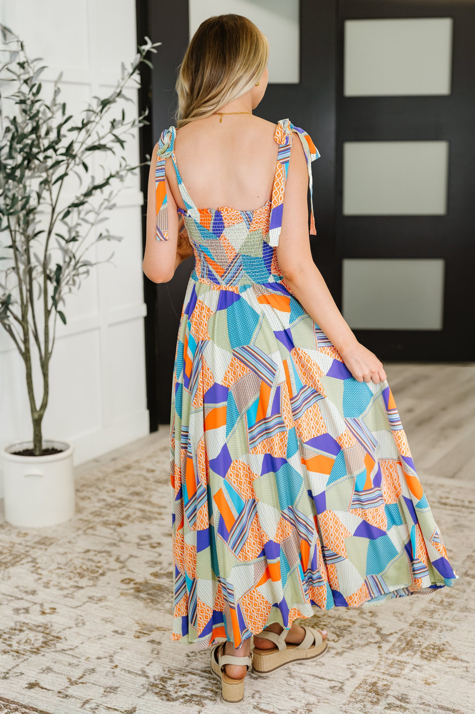Back view of Wrenleigh multicolor maxi dress with smocked bodice, tie straps, and bold colorful pattern.