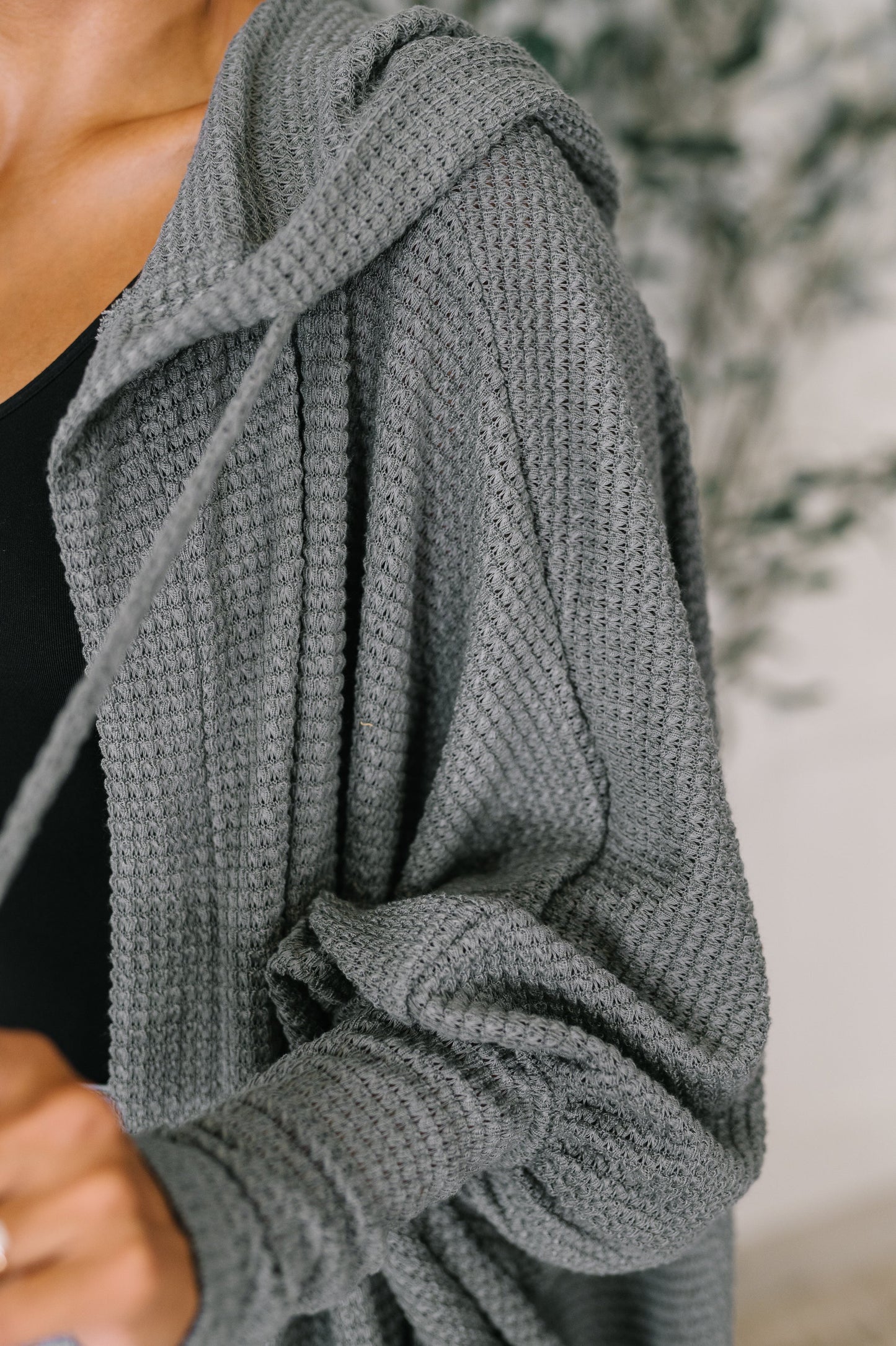 Close-up of Remington Hooded Cardigan in charcoal showing soft waffle knit texture and draped hood.