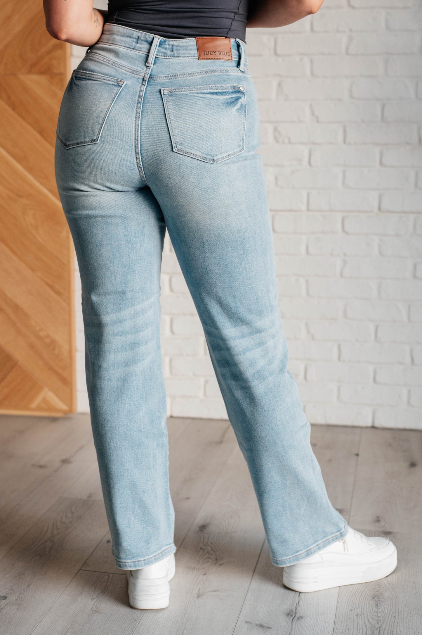 Back view of the 90s-inspired Patricia High Rise Rigid Magic Straight Jeans in a distressed light wash, featuring a classic straight-leg fit and a comfortable cotton-stretch denim blend for timeless style.