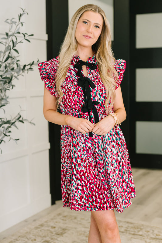 Woman wearing Jocelyn Bow Detail Dress in fuchsia with black bows