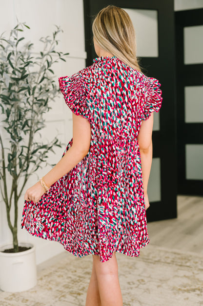 Back view of Jocelyn Bow Detail Dress in fuchsia and black, flutter sleeves visible.
