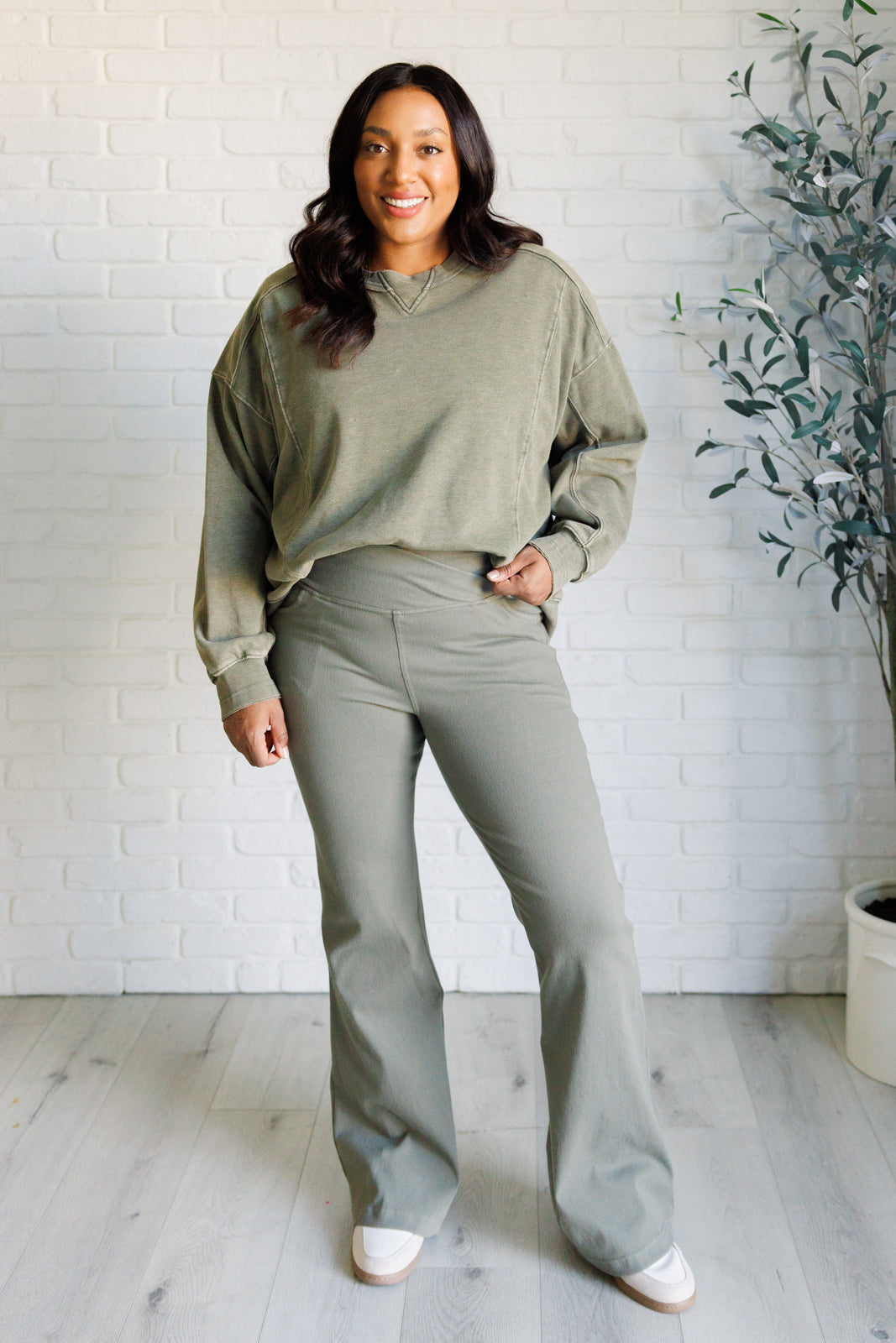 Twill Flared Crossover Waist Pants in dusty olive with a high V-waistline, medium-stretch fabric, flared legs, and functional front and back pockets.