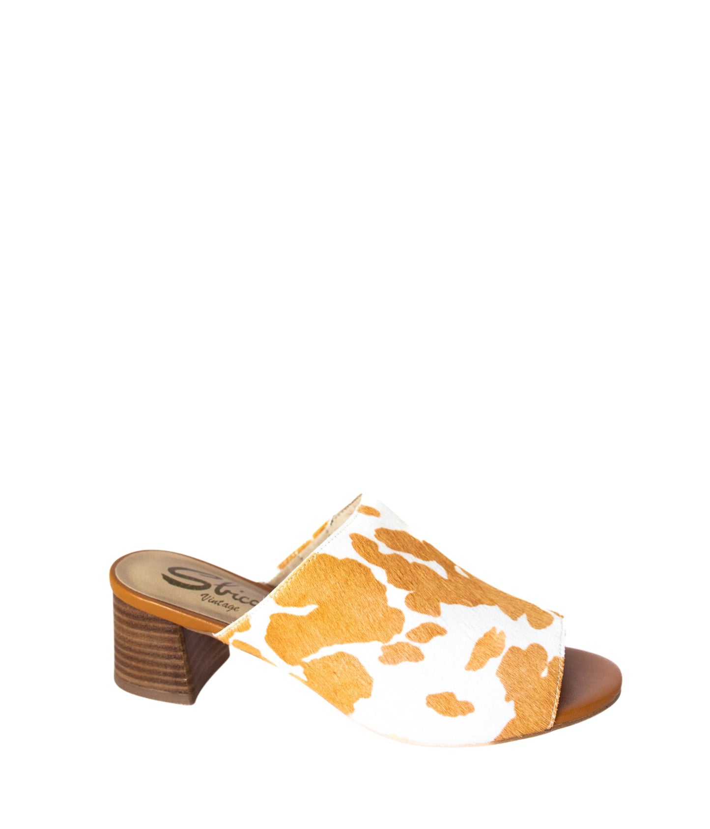 Tan and white cow print mule shoes for women, featuring a genuine calf-hair upper, synthetic lining, padded insole, and internal elastic gore for comfort. Designed with a low stacked leather heel, these slip-on mules are perfect for pairing with jeans, jumpsuits, or other outfits to add a playful, bold touch.