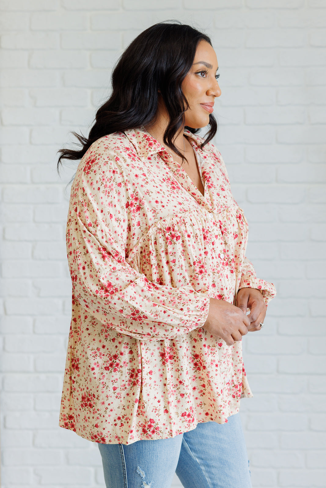 Women's pink floral button-up shirt with a collared neckline, button closures, balloon sleeves, and ruffle details, made of lightweight poplin fabric.