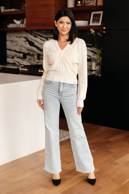 Model wearing Raquel Surplice Crop Sweater in cream with shawl collar and v-neck.