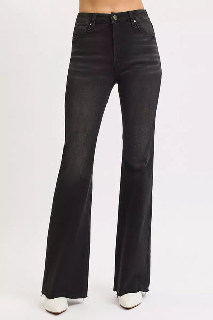 Model wearing black high rise flare jeans, styled with fitted top for chic look.