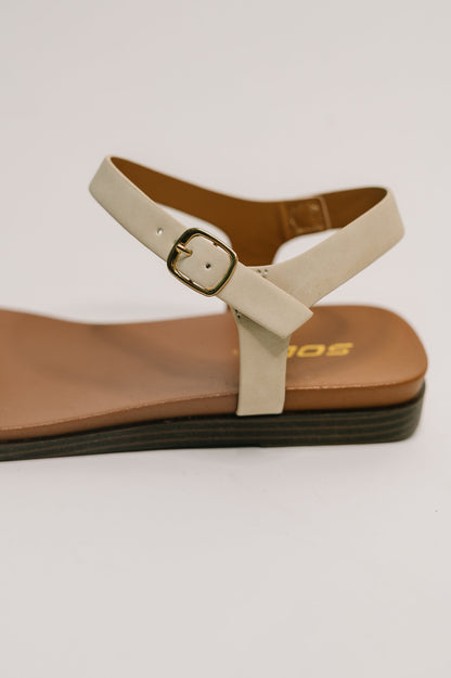 Close up of Riddle Ankle Strap Sandals nubuck texture and gold hardware.